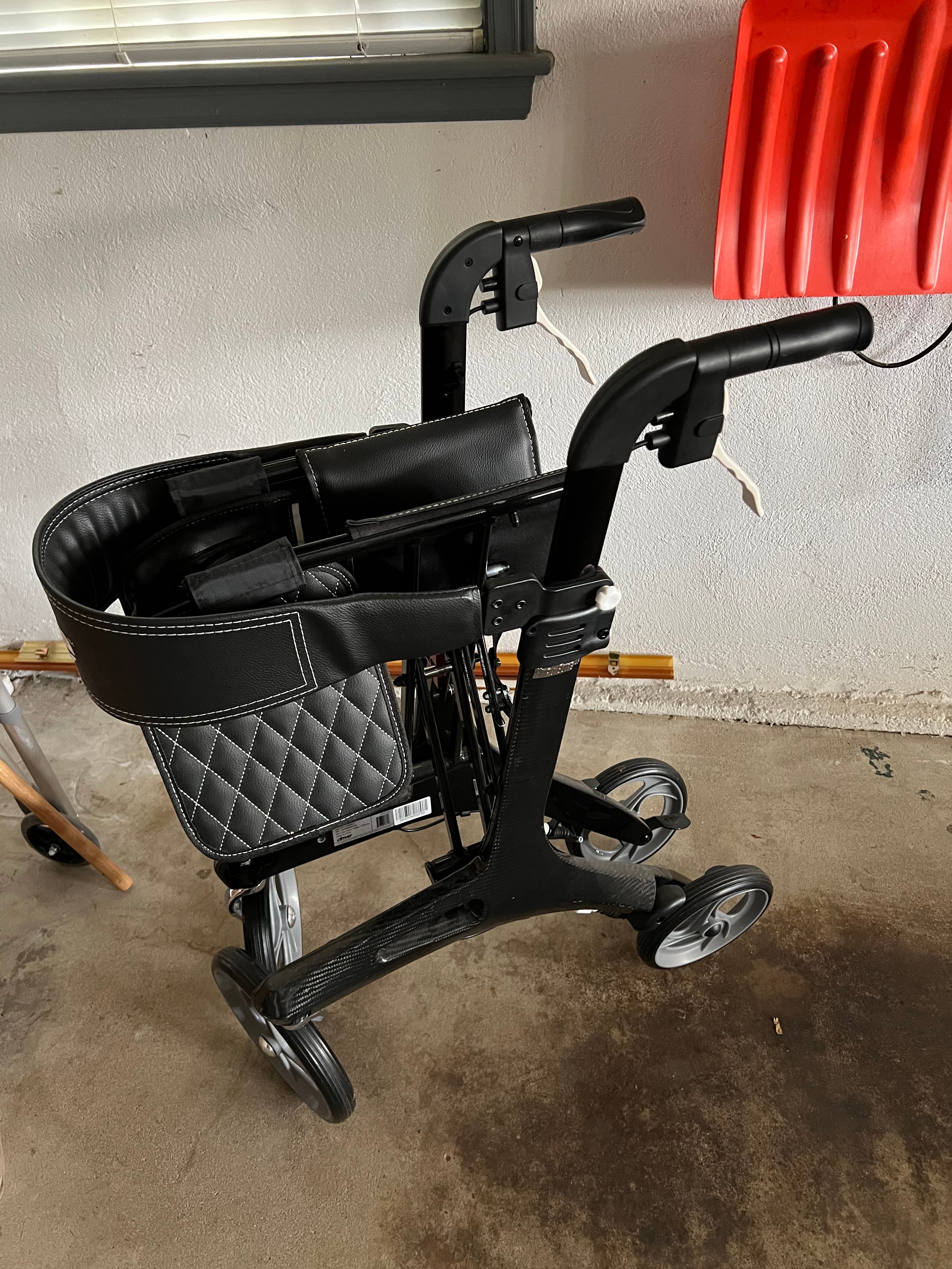 Rollator (walker with wheels that folds and includes seat/storage